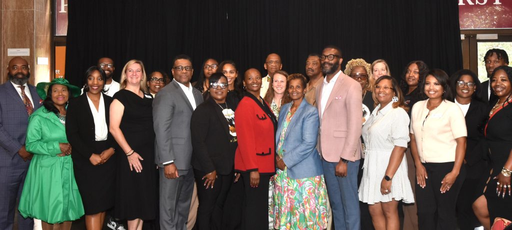 Birmingham Mayor Randall Woodfin and City Council President Pro Tem LaTonya Tate pose with representatives of the 14 agencies receiving microgrants during a press conference on Apr. 27, 2026.